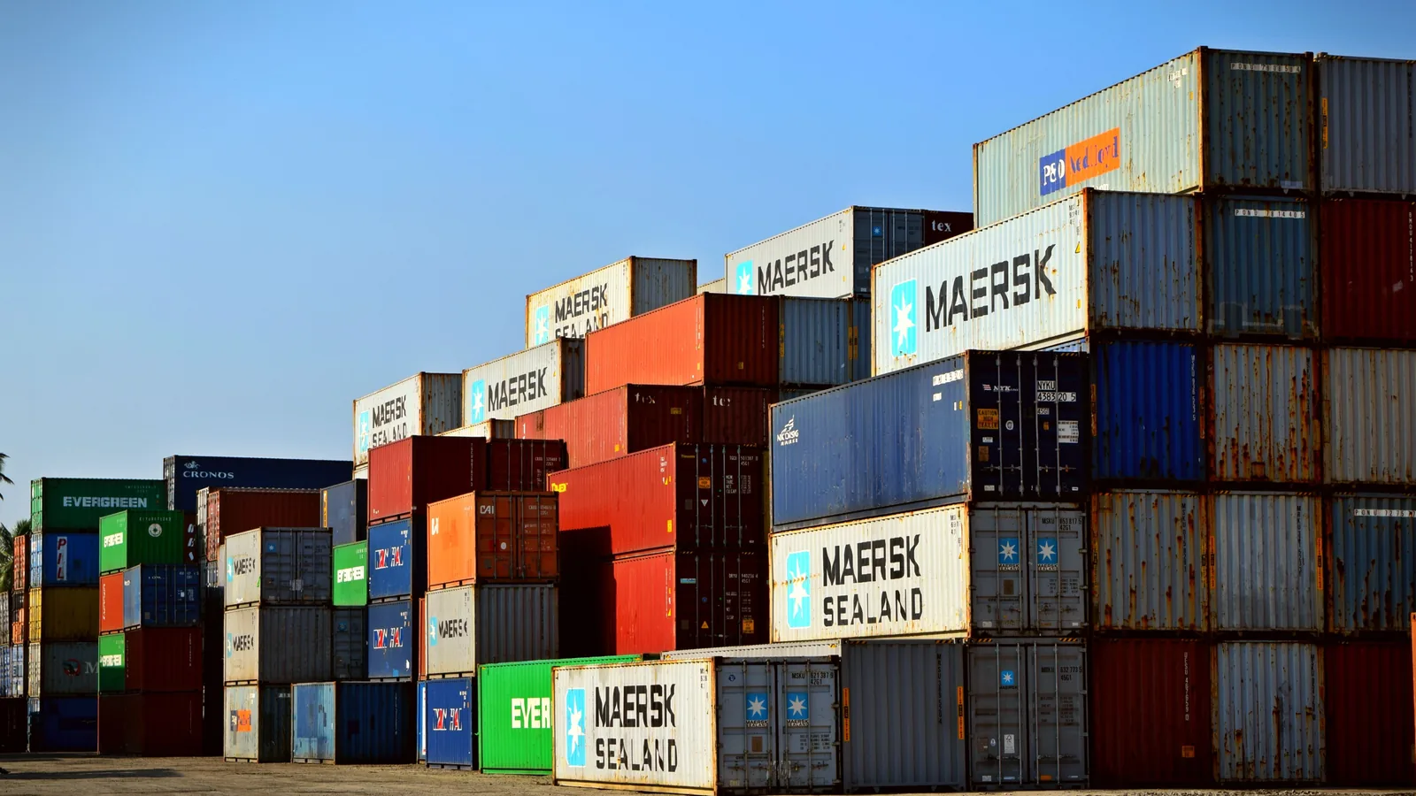 Stacked shipping containers in a terminal yard.