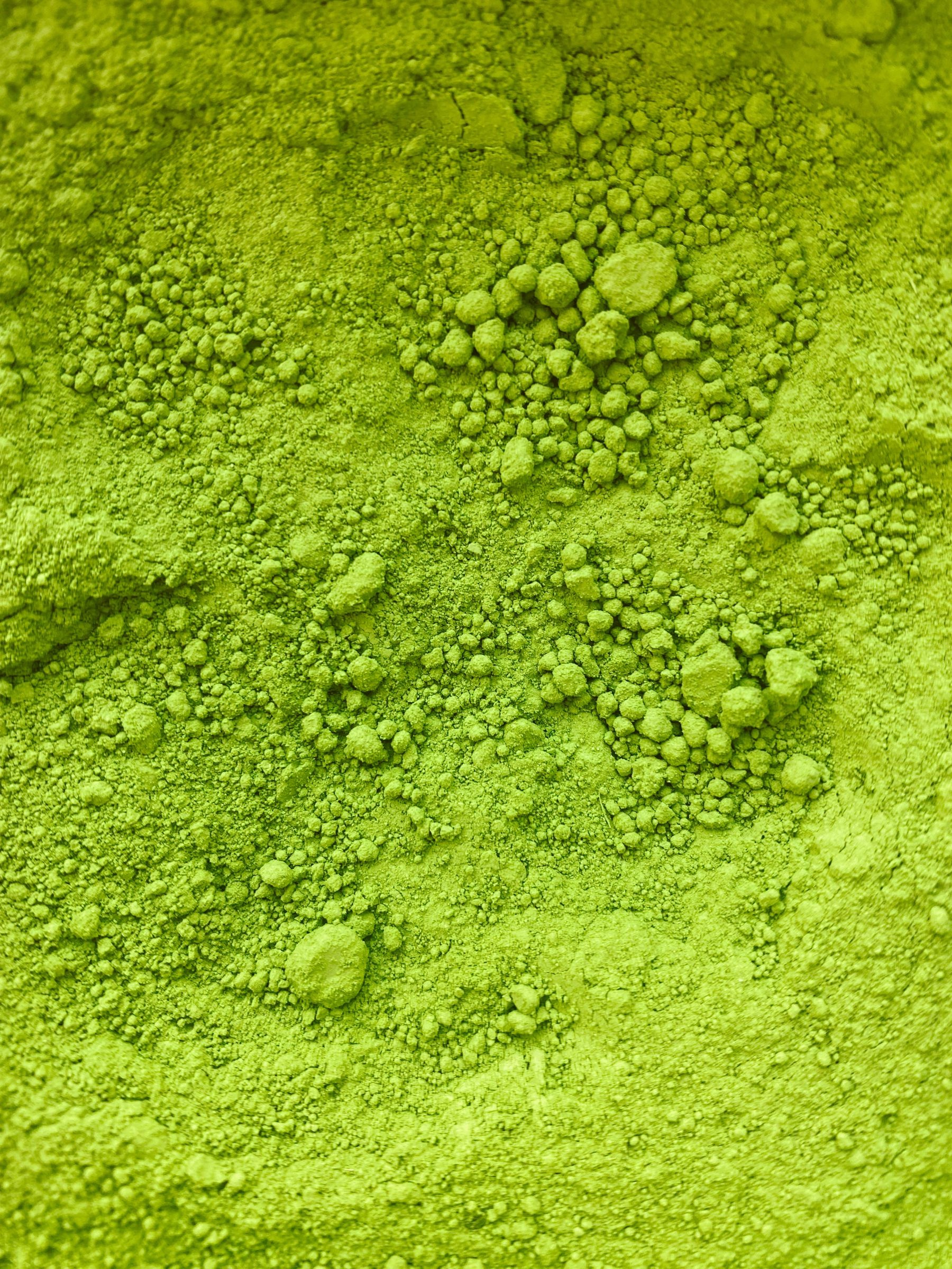 Fine poudre de thé vert photographiée sur une surface unie
