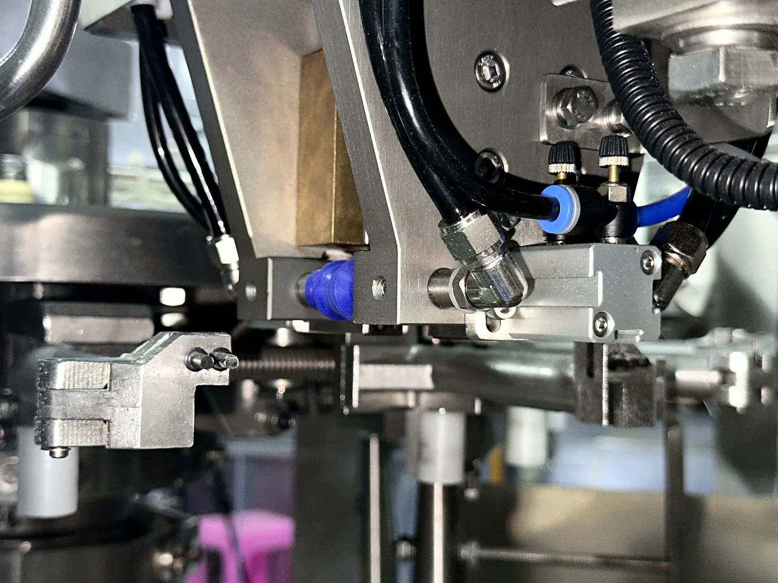 Pneumatic actuator and air-line detail inside a rotary packing machine.