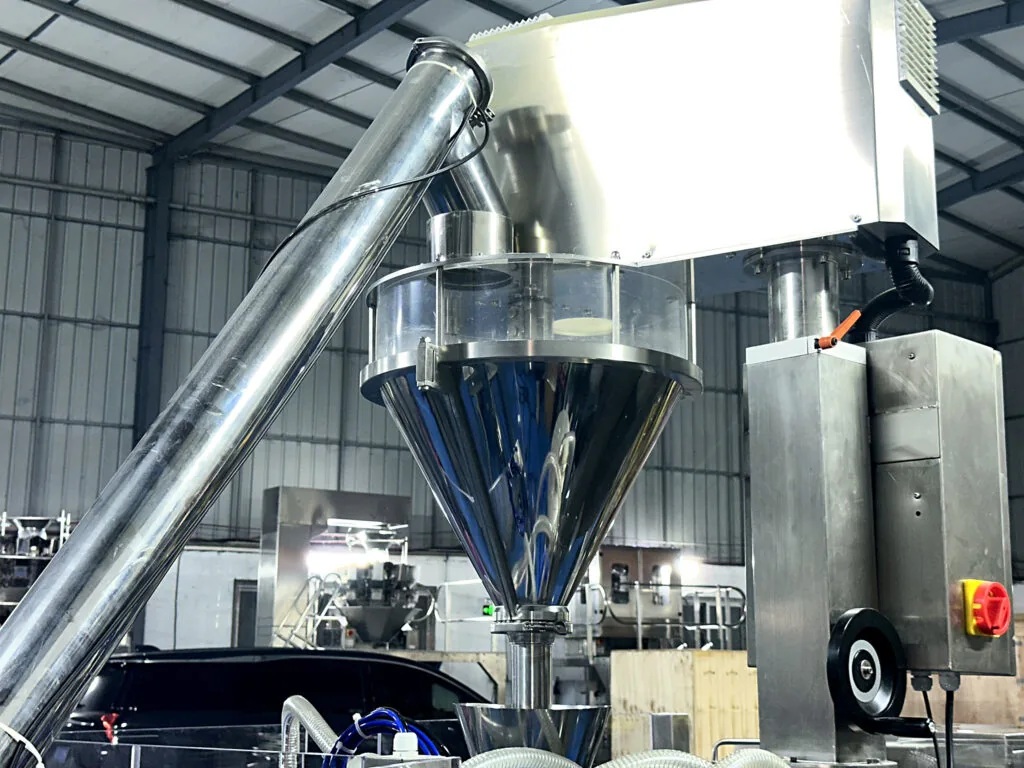 Auger dosing assembly above a rotary premade pouch packing machine.